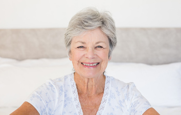 おがた歯科の特徴ー御年配の方のためのホッとトリートメントのイメージ画像。歯並びの良い年配の女性が微笑んでいる